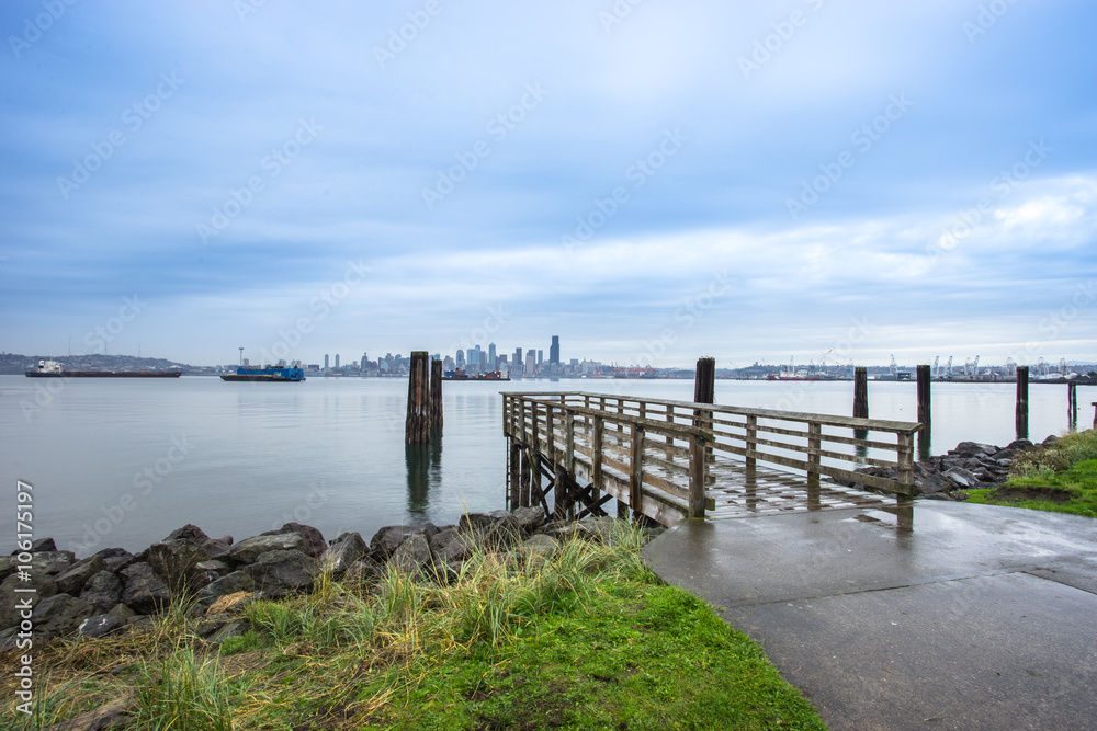 old wood footpath near lake and cityscape of seattle in cloudy s