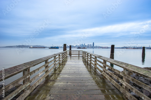 old wood footpath near lake and cityscape of seattle in cloudy s © zhu difeng