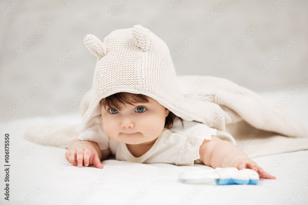 Portrait of baby girl crawling on blanket indoors