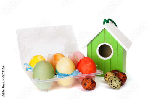 A small nesting box with colored eggs, isolated on white background