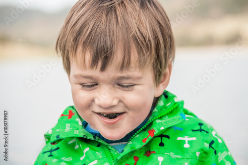 Little boy outdoors eating and laughing