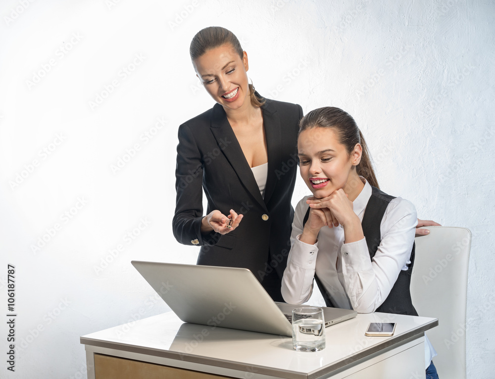 Two business women work at the laptop Two business women work at the laptop