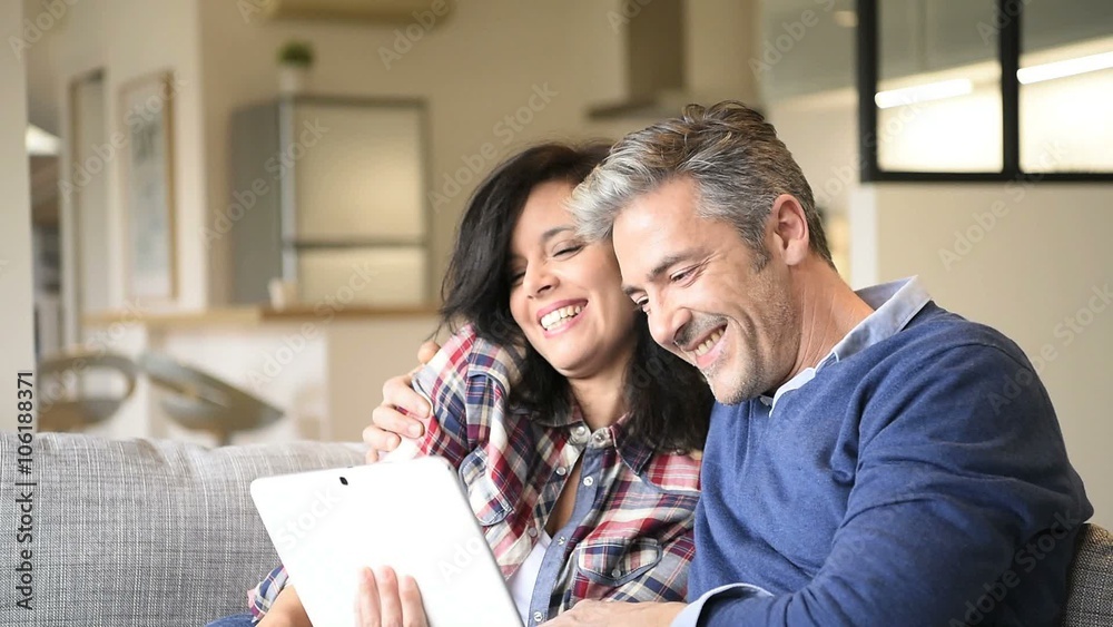 Couple at home websurfing with digital tablet