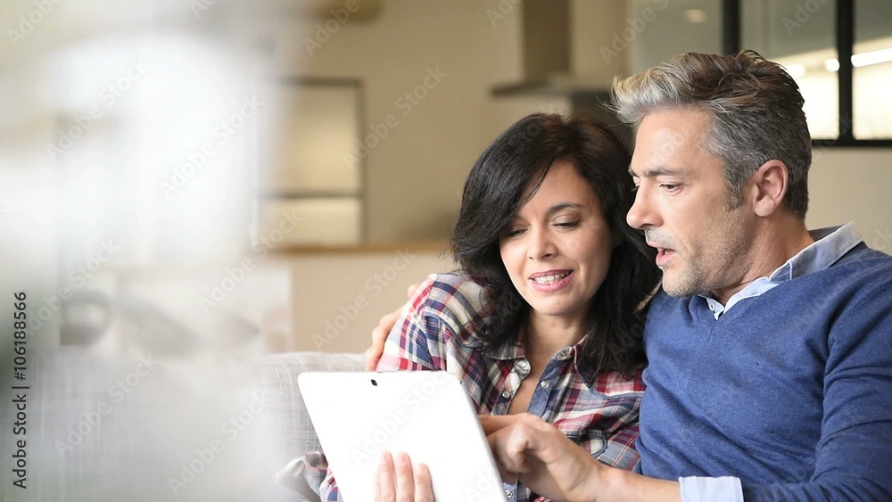 Couple at home websurfing with digital tablet