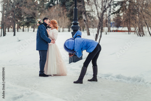 Wedding photographer taking photographs of groom and bride © EdNurg