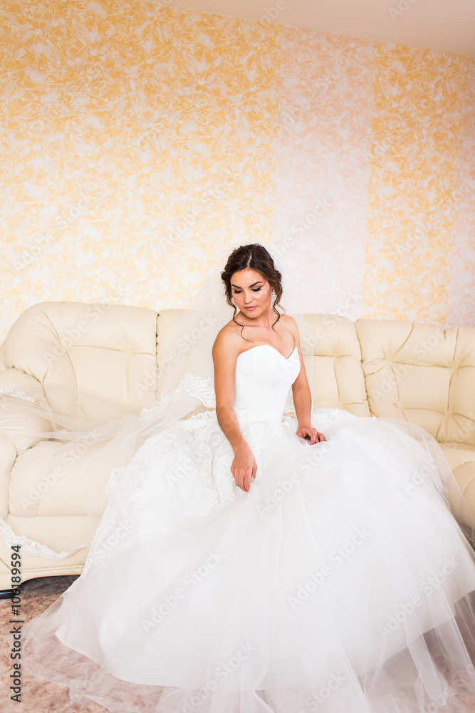 Beautiful bride in the interior sitting on couch Beautiful bride in the interior sitting on couch