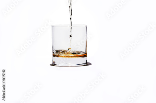 Ein Glas Whiskey mit Splash, isoliert auf weißem Hintergrund photo