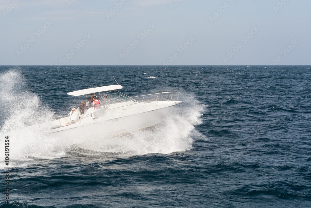 MIRISSA, SRI LANKA - JANUARY 2016: White Motor Boat Rushing Through the Waves in Indian Ocean Close to Sri Lanka Coast MIRISSA, SRI LANKA - JANUARY 2016: White Motor Boat Rushing Through the Waves in Indian Ocean Close to Sri Lanka Coast