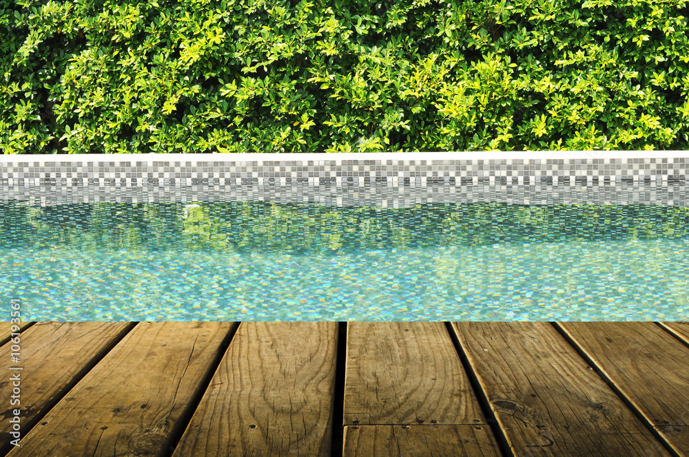 Obraz premium Swimming pool with tree fence and grunge wood plank