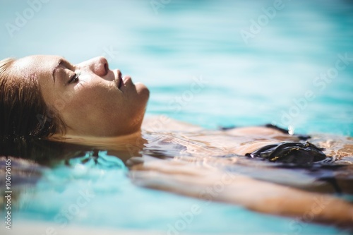 Peaceful blonde floating in the pool