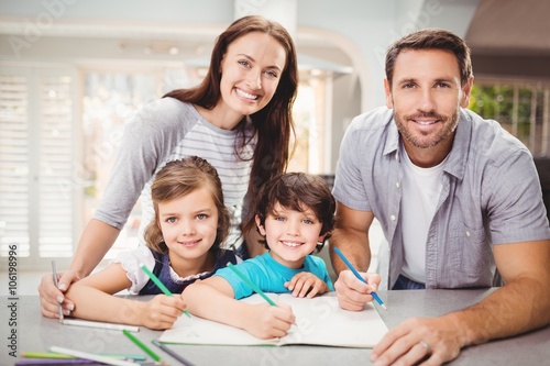 Portrait of smiling family writing in book