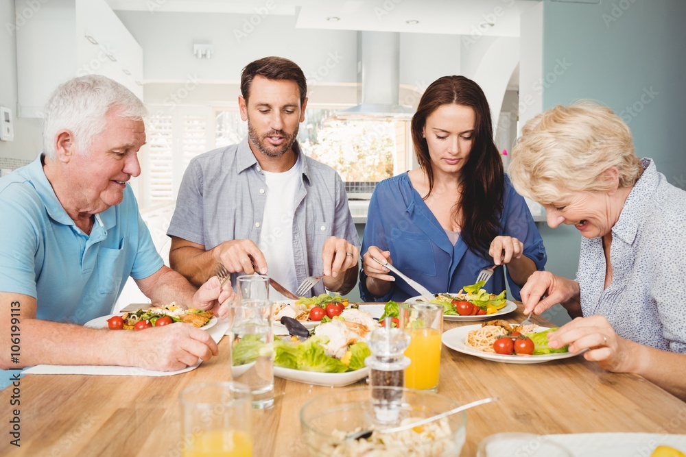 Family sitting at dining table with food Family sitting at dining table with food
