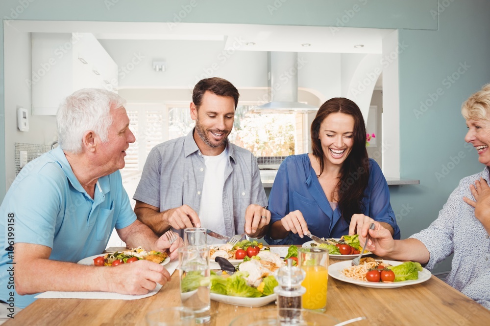 Family laughing while sitting at dining table Family laughing while sitting at dining table