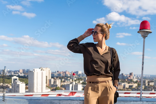 High fashion look. glamor stylish sexy beautiful young blond model girl in bright casual clothes behind blue sky