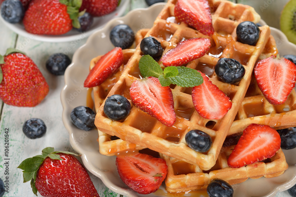 Obraz premium Waffles with berries and caramel sauce