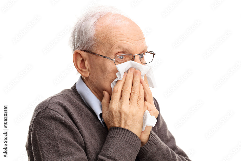 Senior man blowing his nose in a tissue Senior man blowing his nose in a tissue