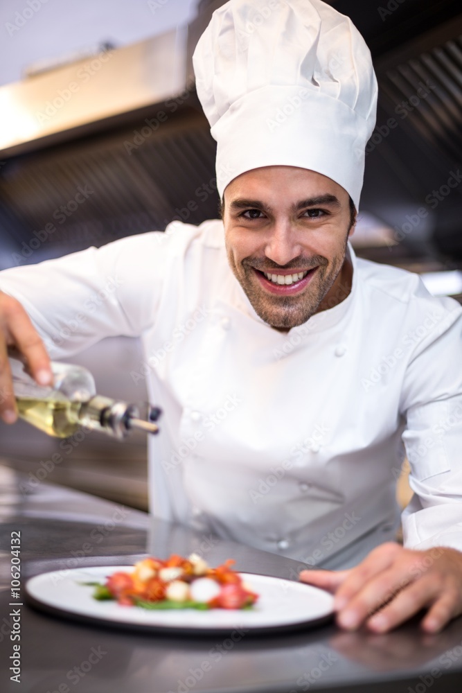 Handsome chef pouring olive oil on meal Handsome chef pouring olive oil on meal