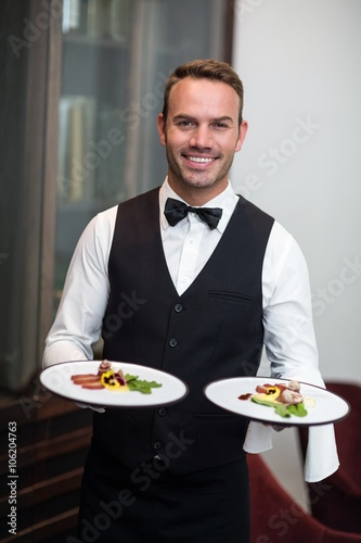 Portrait of waiter presenting meals photo