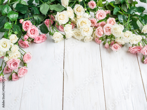 Delicate fresh roses on the white wooden background. © volff
