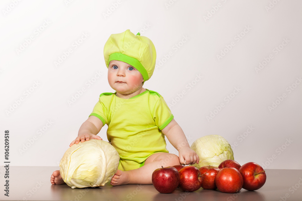 child with cabbage and apples on a white background in studio child with cabbage and apples on a white background in studio