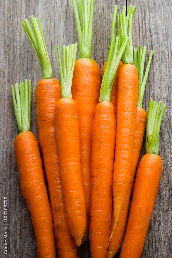Fresh carrots bunch on rustic wooden background. Fresh carrots bunch on rustic wooden background.