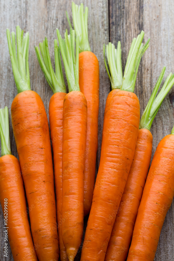 Fresh carrots bunch on rustic wooden background. Fresh carrots bunch on rustic wooden background.