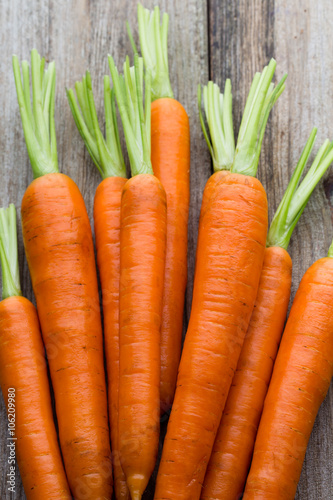 Fresh carrots bunch on rustic wooden background.
