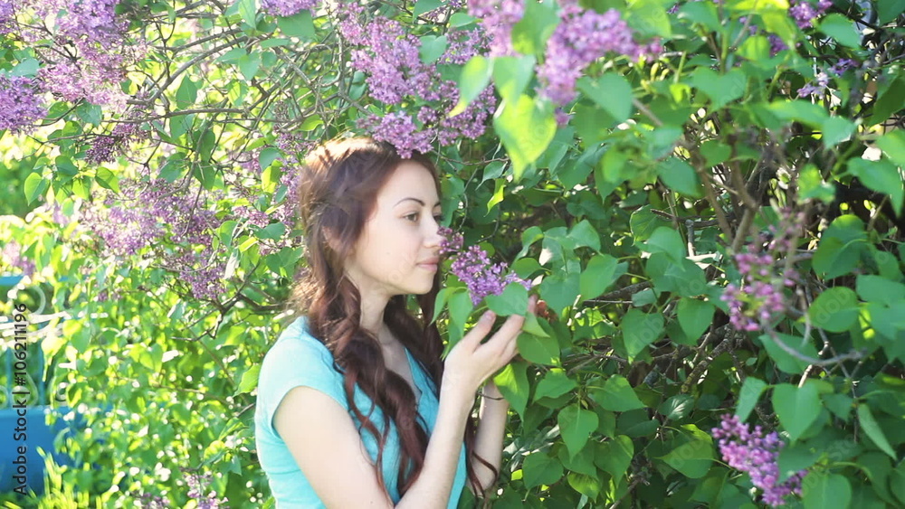 beautiful woman near lilac tree in spring park