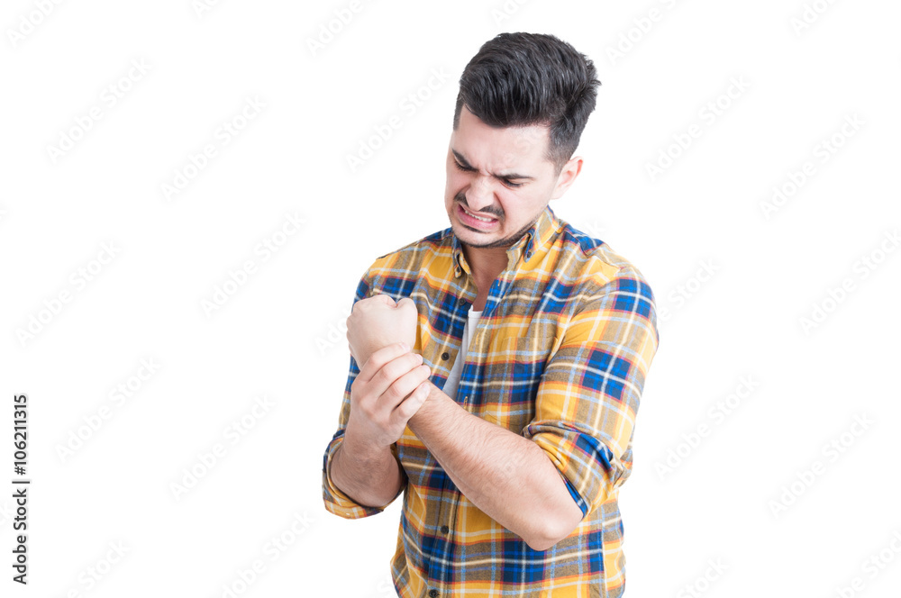 Attractive male model holding his wrist in pain Attractive male model holding his wrist in pain