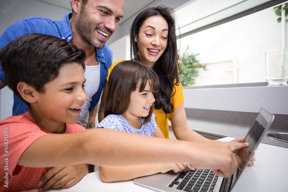 Fotografie Happy family interacting using laptop