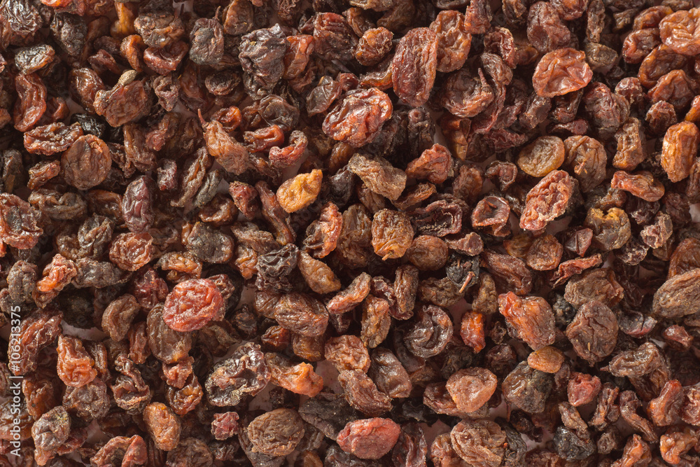 Macro background with a pile of raisins and wooden spoon Macro background with a pile of raisins and wooden spoon