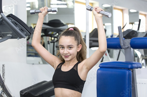 Girl is engaged in sports and gymnastics in the gym
