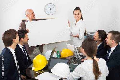 Smiling business people presenting products plan photo