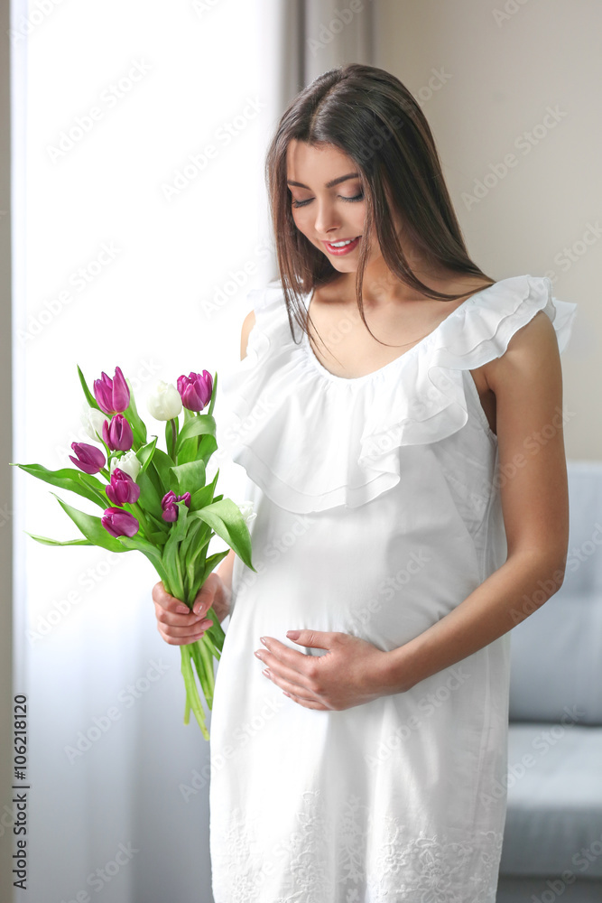 Pregnant woman with beautiful bouquet of tulips in the room Pregnant woman with beautiful bouquet of tulips in the room