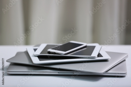 Stack of electronic devices on a white desk