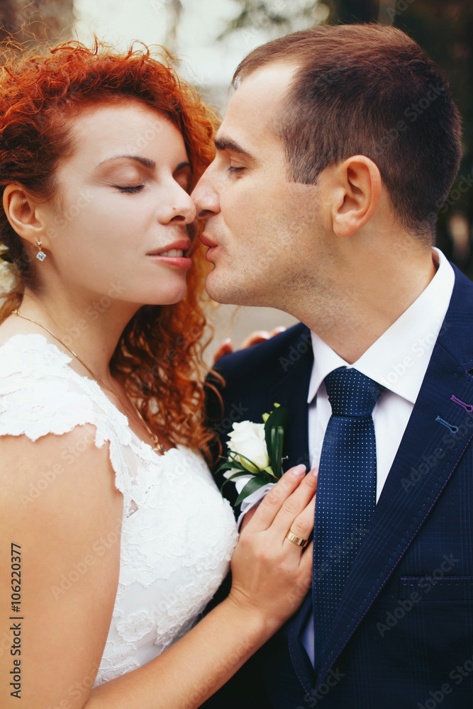 stylish luxury red haired bride and elegant groom, kissing in th stylish luxury red haired bride and elegant groom, kissing in th
