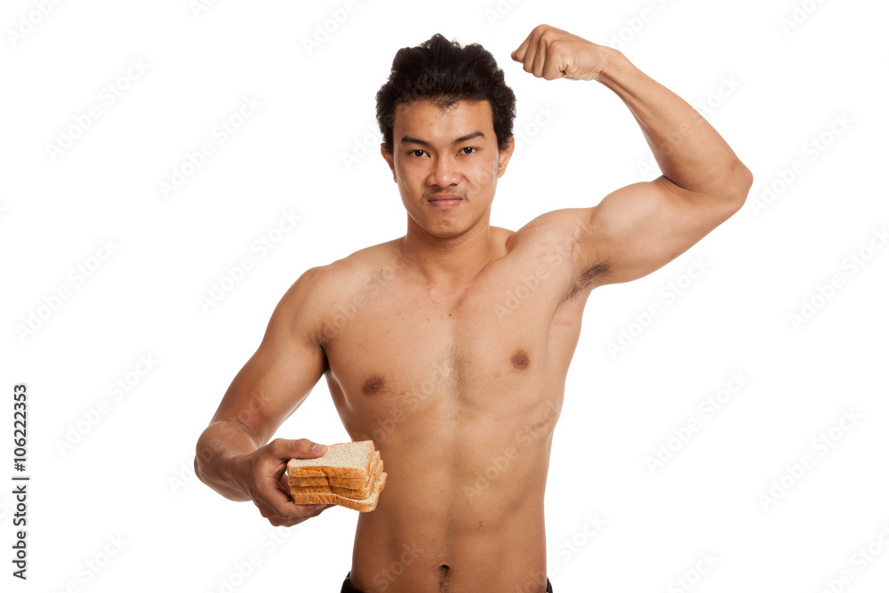 Fototapeta premium Muscular Asian man load carbs with some bread flexing biceps