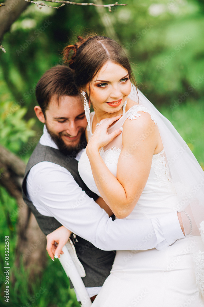 Bride and groom posing at the decorated banquet table in the park in the summer. Enjoy a moment of happiness and love. A series of photos in my portfolio. Groom with beard Bride and groom posing at the decorated banquet table in the park in the summer. Enjoy a moment of happiness and love. A series of photos in my portfolio. Groom with beard