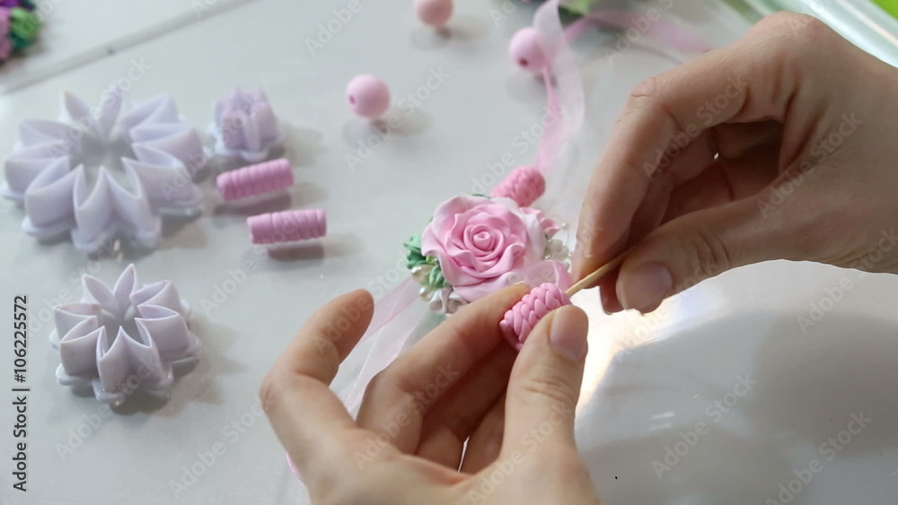Artist makes jewelry from color Polymer Clay, artist at work. Workshop. Hobby – Art Clay Modeling. Tools for modeling. Handmade Production. Plasticine. Hands makes a pink rose Artist makes jewelry from color Polymer Clay, artist at work. Workshop. Hobby – Art Clay Modeling. Tools for modeling. Handmade Production. Plasticine. Hands makes a pink rose