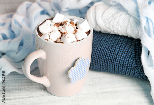 Winter cocoa marshmallow mug knitted sweater on wooden backgroun