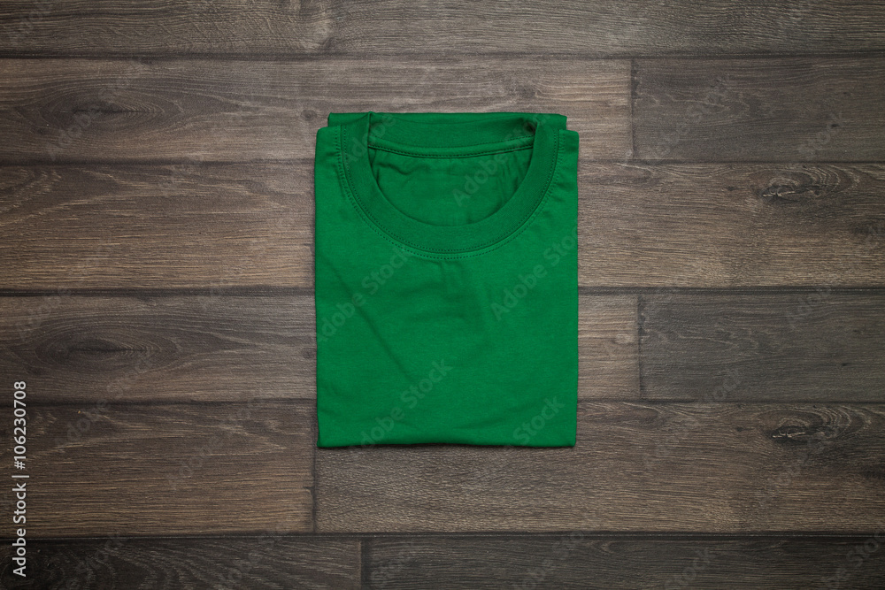 Green blank t-shirt on wooden background Green blank t-shirt on wooden background