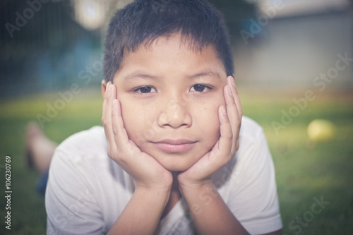 Young Asian boy with hand on face thinking