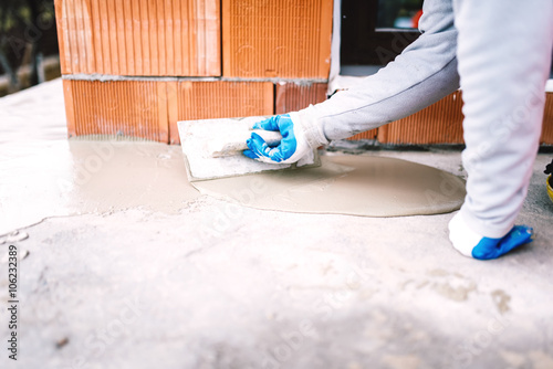 industrial worker waterproofing part of house exposed to rain photo