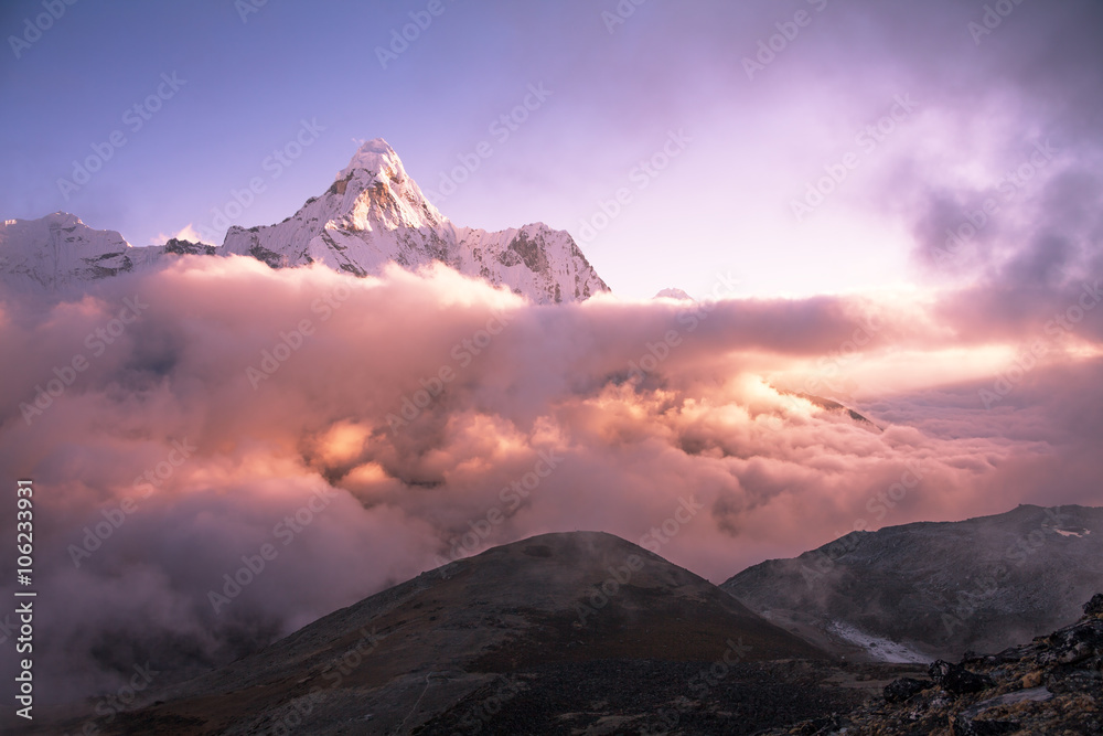 Ama Dablam peak (6856 m) above the clouds at sunset.  Nepal, Himalayas.
