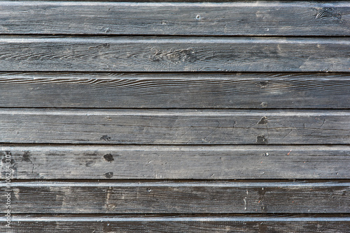 Section of grey black wooden panelling from a seaside beach hut. Ideal as a background for gardening or industrial themes.