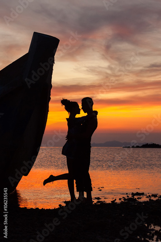 Silhouette of the embracing couple near the shipwreck
