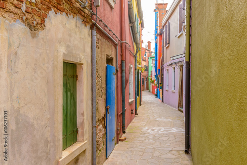 Colorful apartment buildings at very narrow street in Burano, Venice, Italy. © karamysh