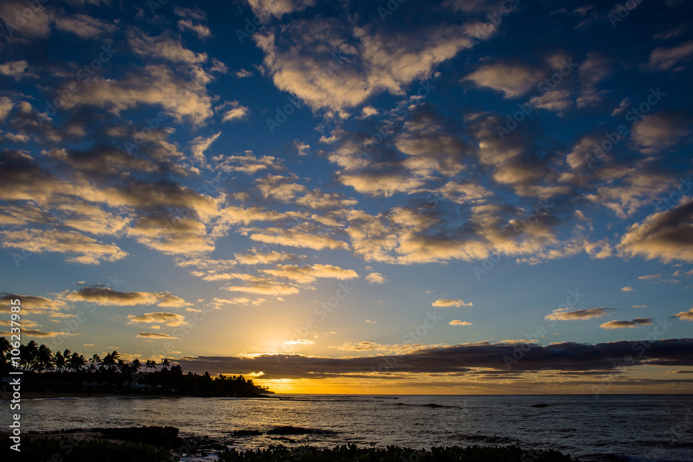 Dramatic clouds and sunrise over Poipu Beach