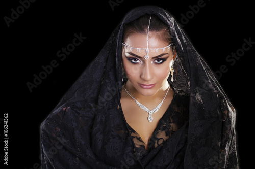 Portrait of a beautiful woman with arabian makeup in black paran