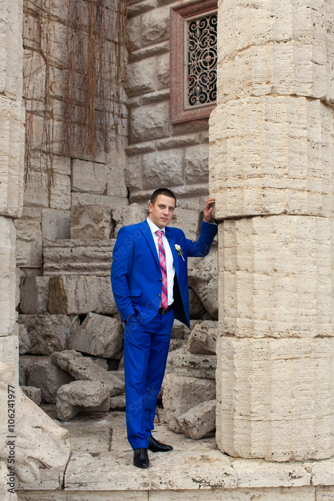 The groom in a blue suit while waiting for the bride